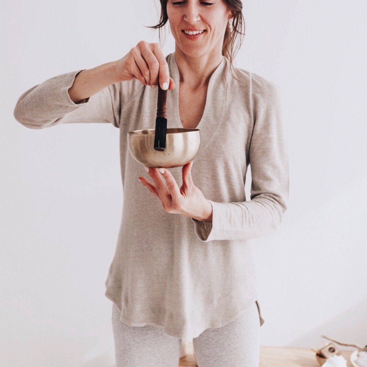 Woman playing a singing bowl in the natural hemp Harmony Tunic